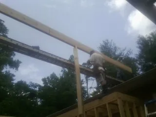 Carpenter setting a ridge beam over a new addition frame — Ice Dam Removal by Roofing Brothers in Red Lodge