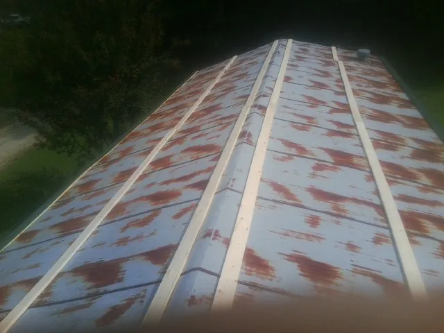 Rusted metal roof panels with new wood purlins before replacement — Storm Damage Roof Repair in Red Lodge by Roofing Brothers